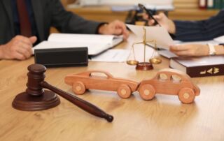 Wooden cars with judge's gavel on lawyer's table during meeting in office.