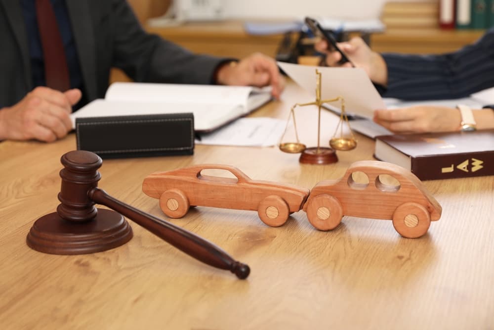 Wooden cars with judge's gavel on lawyer's table during meeting in office.