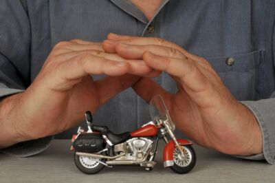 Motorcycle accident lawyer covering a model of motorcycle with his hands