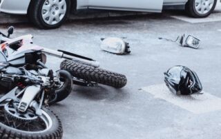 Car mirror, headlight, helmet and motorcycle lying on the road after a car crash