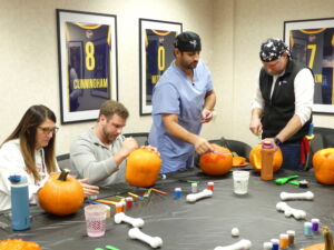 The Hurst Limontes Team Carving Pumpkins for Halloween