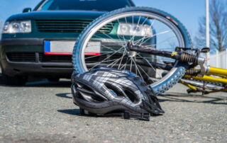 Bicycle accident involving a car with a helmet and damaged bike on the road