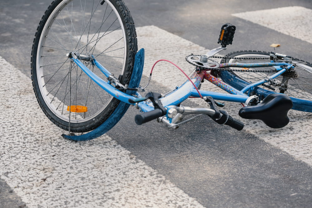 Bicycle lying on a crosswalk after a crash involving a cyclist on a public road