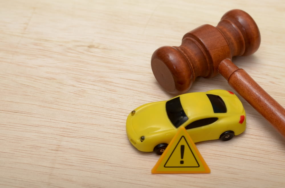 Gavel and toy car representing legal liability and insurance claims after a car accident