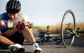 Cyclist holding injured knee after falling in a bicycle accident